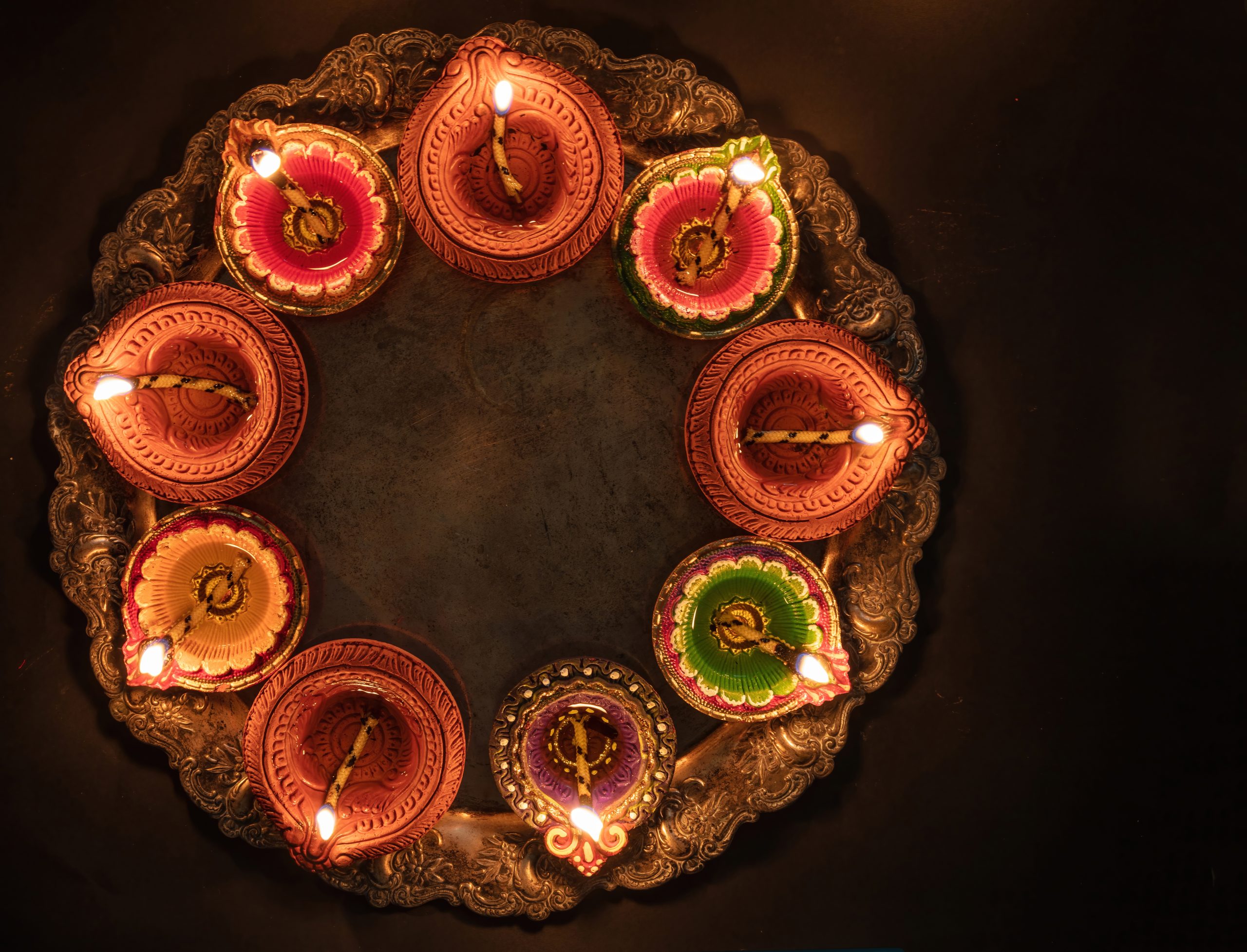 Deepavali Diwali, Hindu Festival of lights celebration. Diya oil lamp lit on traditional Puja thali, top view.