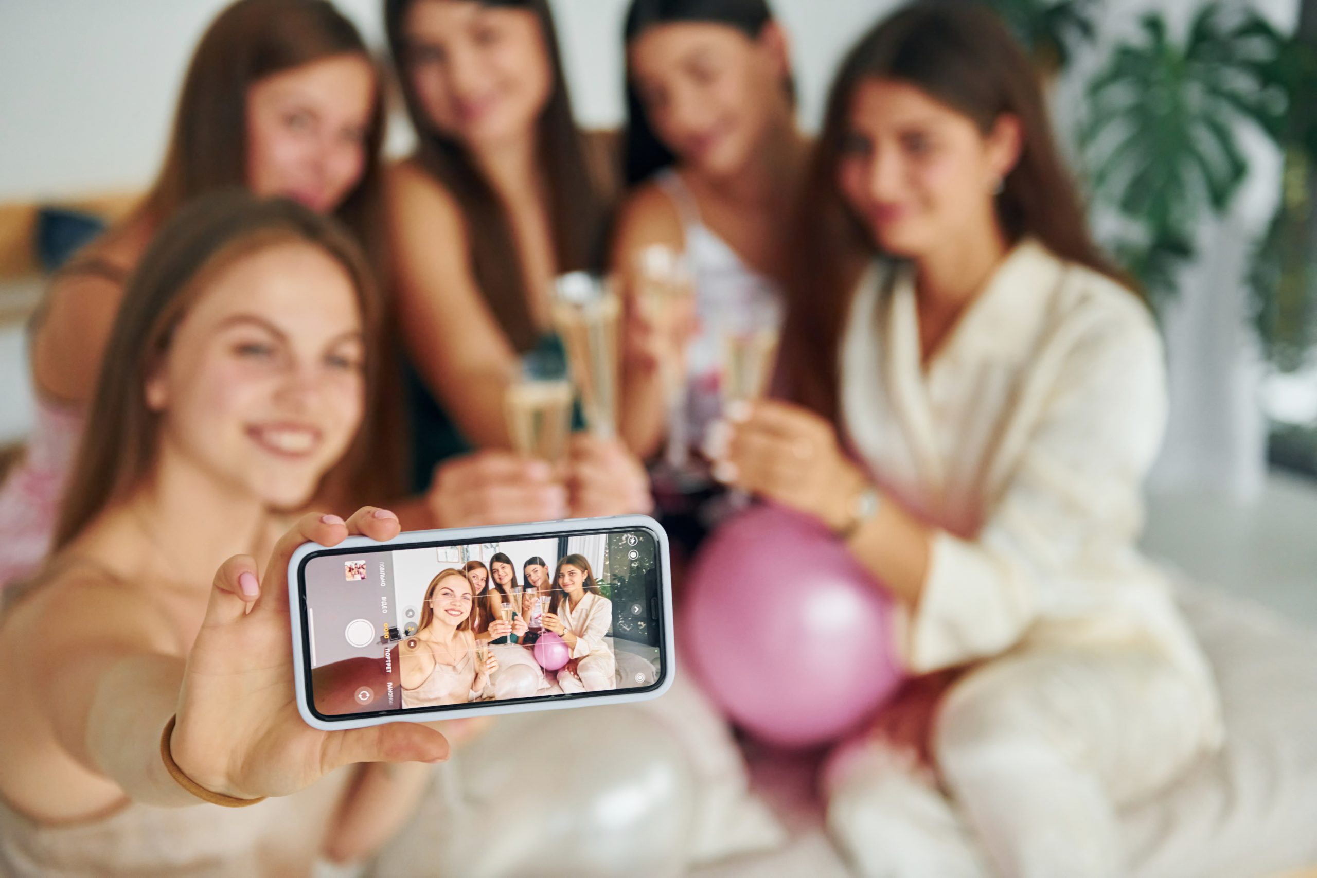 Holding glasses with drink. Group of happy women that is at a bachelorette party.
